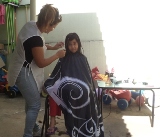Servio Voluntrio: Cabelereira Lucia cortando o cabelo da aluna Mayara do Infantil III B.